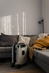 Hard-shell suitcase  in modern living room, travel luggage ready for departure