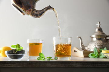 Pouring green tea from a metal teapot isolated background