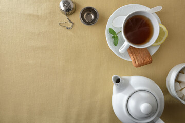 Tea and white ceramic containers on a table with tablecloth