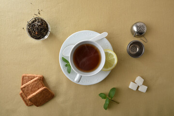 Teacup isolated in the center on brown tablecloth with ingredients
