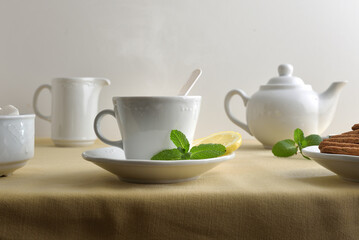 White ceramic tea set on a table with a tablecloth