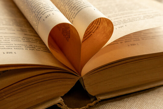 An open book with pages folded into a heart shape, symbolizing a love for reading or a romantic story. A perfect Valentine's theme