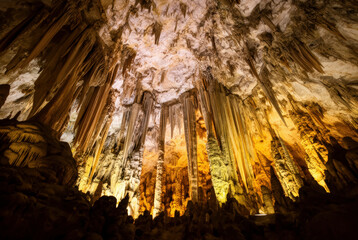 A stunning cave interior with dramatically lit stalactites and rock formations, perfect for backgrounds or artistic projects.