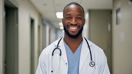 Confident doctor smiling in a hospital hallway, promoting healthcare and professionalism in a clinical setting.