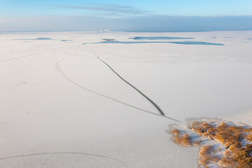 Winter natural landscape: snow and frozen lake view from a drone.