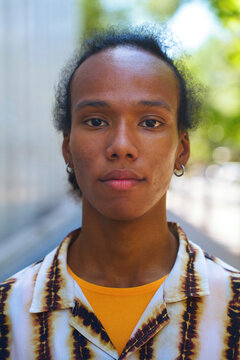 Portrait of a carefree person with earring on a city street outdoors
