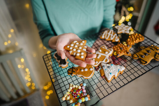 Hand holding Christmas gingerbread cookies with icing at home