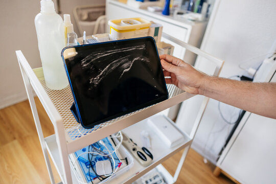 Technician holding ultrasound monitor in medical clinic