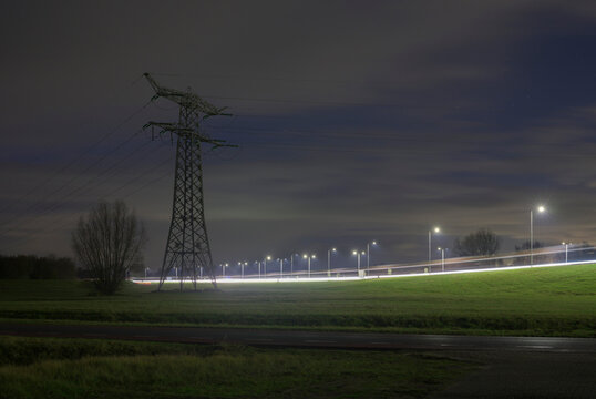 Power line and motorway at night in the Netherlands countryside