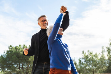 Couple dancing joyfully together in a garden outdoors