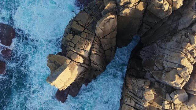 Sea Waves On Cant&iacute;s de Papel Granite Rocks At Sunset Near Xove In Lugo, Galicia, Spain. Aerial Topdown Shot