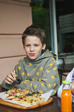 Young friends eating pizza outdoors in Berlin during summer