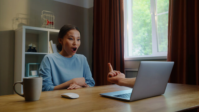 Woman see middle finger remote, obscene hand fuck you gesture from laptop screen. Person visit suspicious phishing scam website. Online gambling fail. Work failure. Funny joke, humor. Internet fraud.
