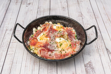 A plate of broken eggs for one person, with one egg, potatoes, and a little ham&mdash;perfect for breakfast or a snack.