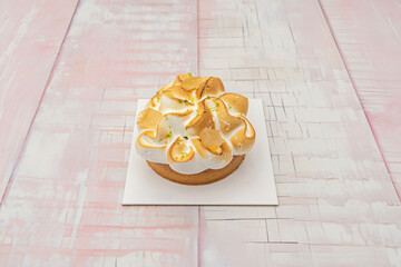 a close-up of the moment when the back of a spoon breaks the toasted surface of the meringue, plunging into the lemon cream