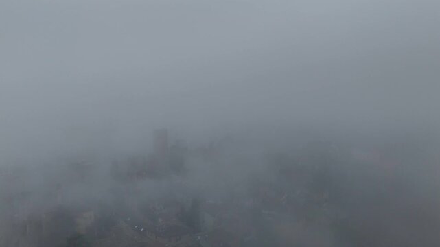 An atmospheric study of the medieval hilltop village of Castell'Arquato during a heavy winter fog.