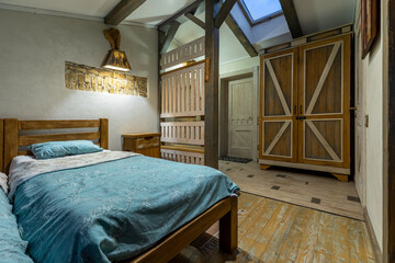 Rustic attic bedroom interior with wooden furniture and evening lighting