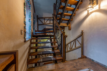 Rustic wooden staircase with tree branch metal railings and mosaic window