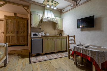 Rustic studio interior with green kitchenette and dining area