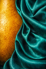 Yellow fruit resting on a smooth, green fabric in a creative setting for 2026 trends