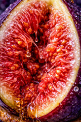 Close view of fig fruit showing texture and juice with droplets on surface in natural light