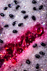 Close-up of pink dragon fruit showing seeds, water droplets, and bright colors in a striking arrangement