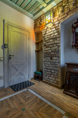Rustic entryway interior with wooden door and brick wall niche