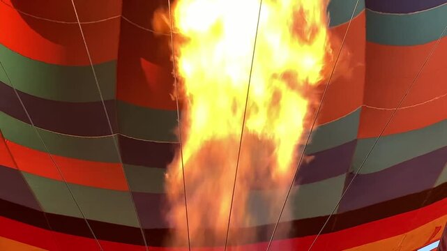 Hot Air Balloon Inflation with Powerful Burner Flame Inside Colorful Balloon Envelope During Preflight Preparation