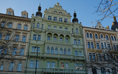 Fototapeta premium Typical Historic Prague architecture, ornate Neo-Renaissance and Neo-Baroque facades. Exterior view of cozy residential buildings with windows with molding. Real estate, Living apartment