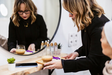 Woman offering coffee to customer in beauty salon
