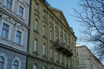 Fototapeta premium Typical Historic Prague architecture, ornate Neo-Renaissance and Neo-Baroque facades. Exterior view of cozy residential buildings with windows with molding. Real estate, Living apartment