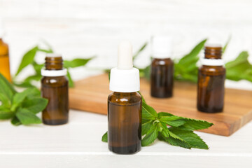 Natural Mint Essential Oil in a Glass Bottle. organic cosmetics with herbal extracts of mint on...