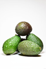 Close up and vertical shot, avocados, tropical fruits, in front shot and white background.	