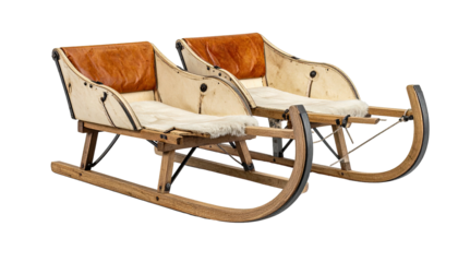 Pair of vintage wooden sleds with cushions, brown leather backs, and metal runners