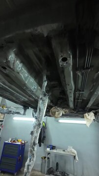 Underbody Sealing With Paper Coverage, Closeup Of Floor Panel And Supports Illuminated, Detailed Underbody Cavity Masked With Paper For Rustproofing Inspection In Vehicle Garage Setting