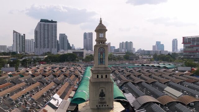 Famous Chatuchak weekend market clock tower, iconic landmark in Bangkok. Aerial view of city skyline and traditional market stalls