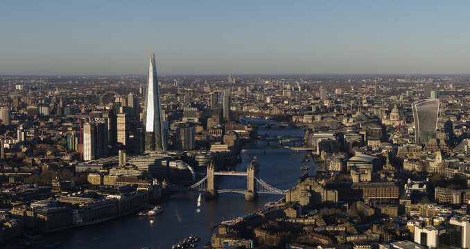 Aerial view of the River Thames snaking through the city, flanked by the iconic Tower Bridge and the modern, glassy Shard, London, England, United Kingdom.