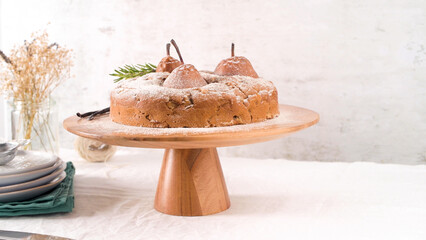 Rustic Pear and Spiced Cake Dusted with Powdered Sugar on Wooden Stand