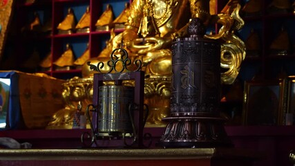 Golden Buddhist Statues and Spinning Prayer Wheel Inside Mongolian Temple