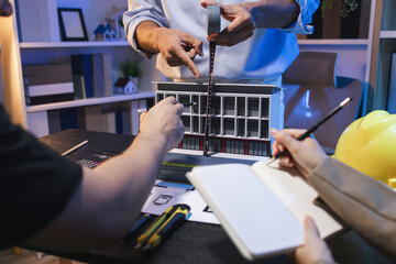 A group of engineers and architects collaborate on a construction project, discussing ideas and sharing technical plans to design innovative modern buildings in a creative teamwork environment.