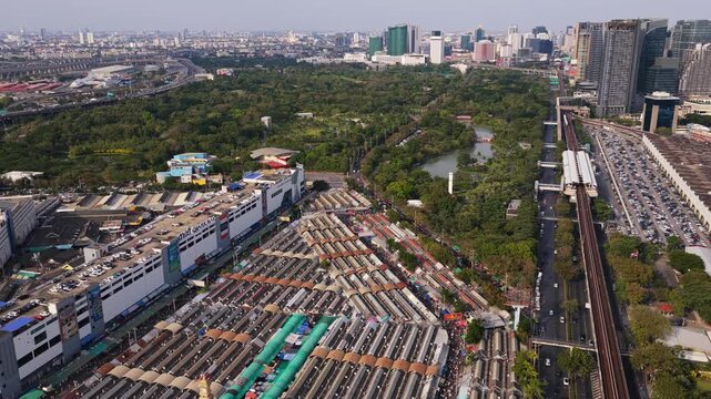 Stunning aerial panorama of famous Chatuchak Weekend Market, Chatuchak Park, and urban transportation in vibrant city of Bangkok