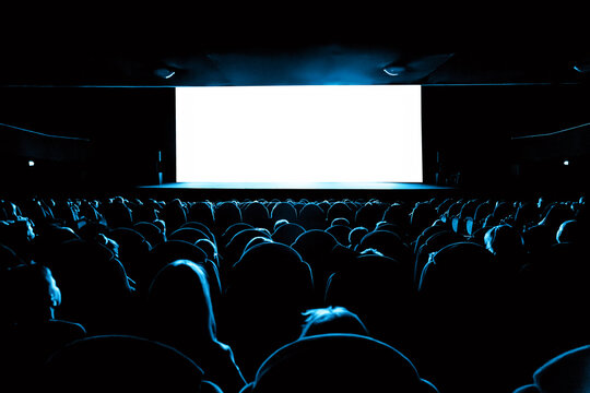 People in the cinema watching a movie. Blank empty white screen