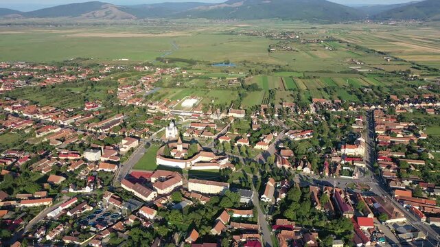 Aerial view of the historic Fortified church standing proudly amidst the town, its white walls contrasting with the red roofs, Prejmer, Brasov, Romania.