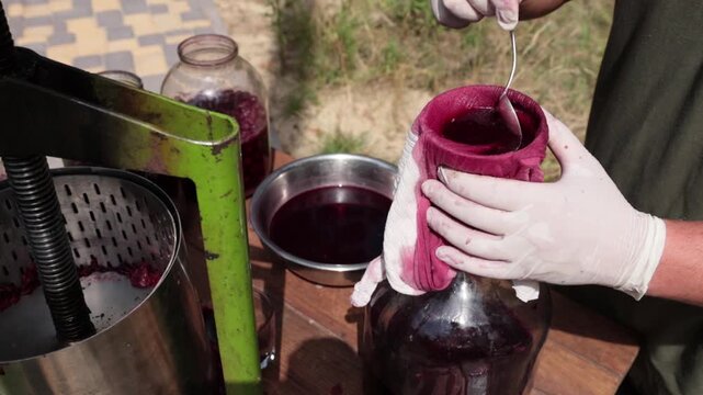 A man makes cherry juice in his garden