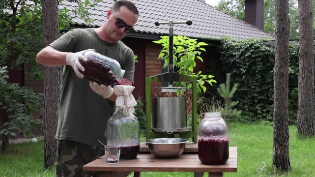 A man makes cherry juice in his garden