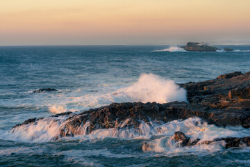 Coastal vista of powerful ocean waves crashing on rocks and with Scarp Island at Yzerfontein. West Coast, Western Cape, South Africa. Seascape for editorial, travel, nature, and ocean-themed licensing