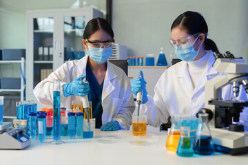 Scientists conducting research in a biotechnology lab, using pipettes and test tubes for medical and chemical experiments. Innovation in chemistry, healthcare, and medicine.