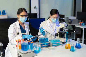 Scientists conducting research in a biotechnology lab, using pipettes and test tubes for medical and chemical experiments. Innovation in chemistry, healthcare, and medicine.