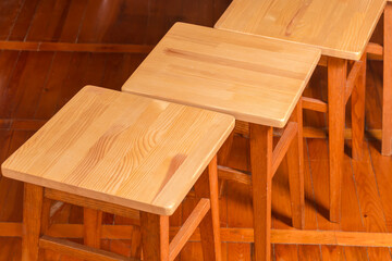 Tops of wooden stools standing on wooden floor, close-up