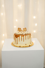 Cake on display with golden decorations and lights in the background during a festive gathering
